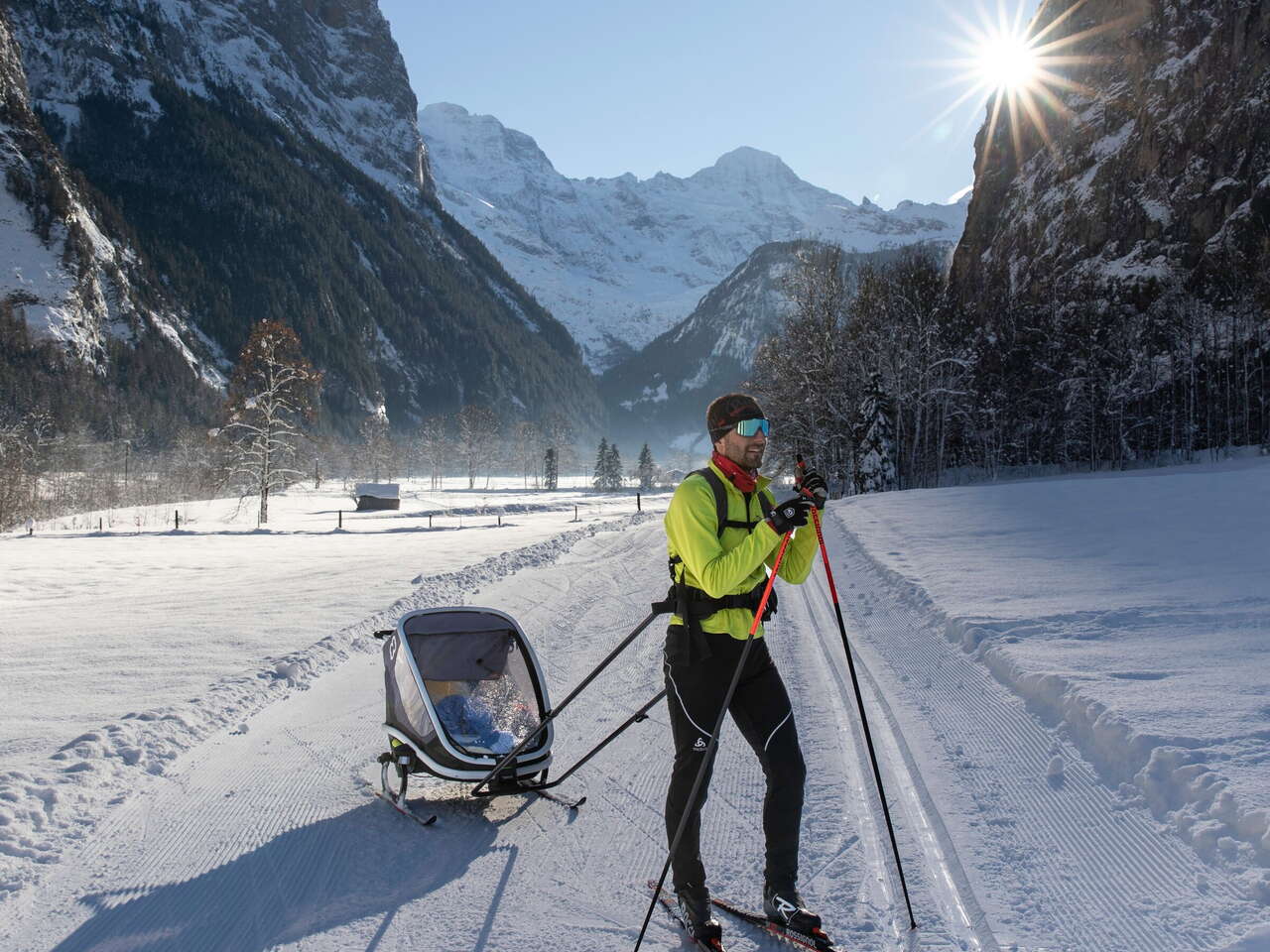 Ein Langläufer unterwegs mit Kinderwagen auf der Loipe in Lauterbrunnen.